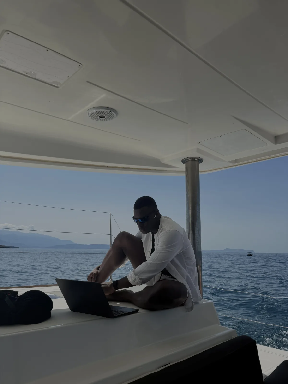Fathin working on a laptop aboard a boat
